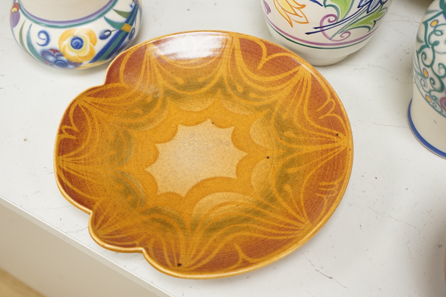 A collection of eight Poole pottery pieces to include vases, bowls and a jar and cover, largest 28cm in diameter